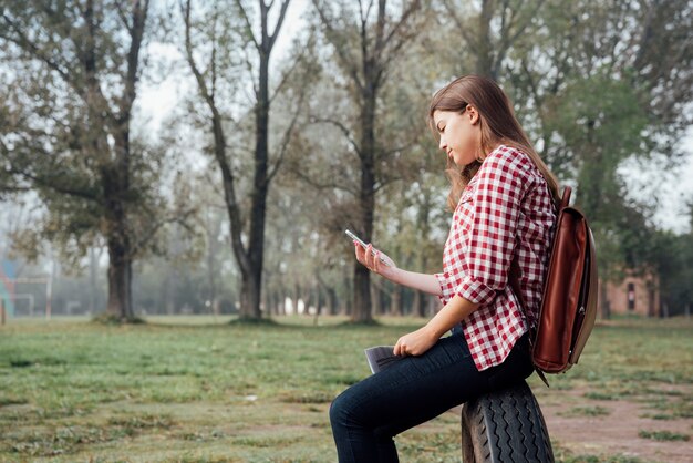 Chica con el pelo largo comprobando su teléfono