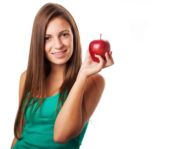 Chica con el pelo largo posando con una manzana