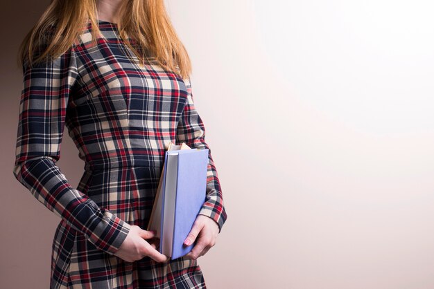 Chica con el pelo largo, vestido y libros