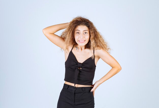 Chica de pelo rizado dando poses desagradables y positivas.