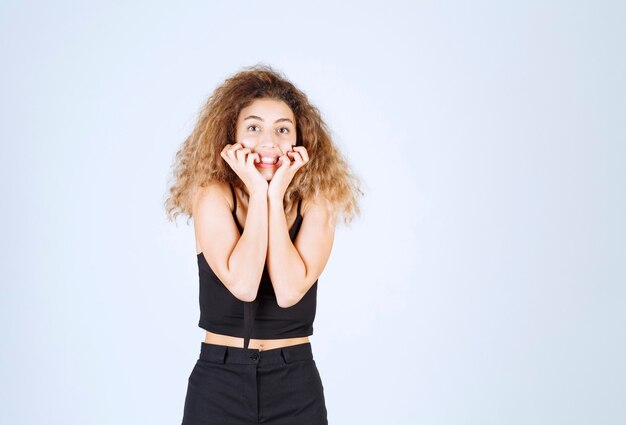 Chica de pelo rizado dando poses desagradables y positivas.