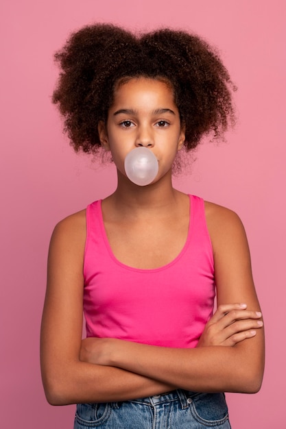 Chica con el pelo rizado haciendo un chicle