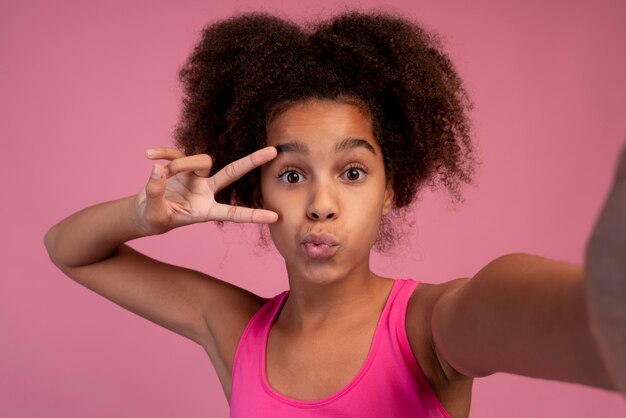 Chica con pelo rizado tomando un selfie