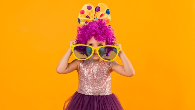 Foto gratuita chica con peluca de payaso y gafas de sol grandes