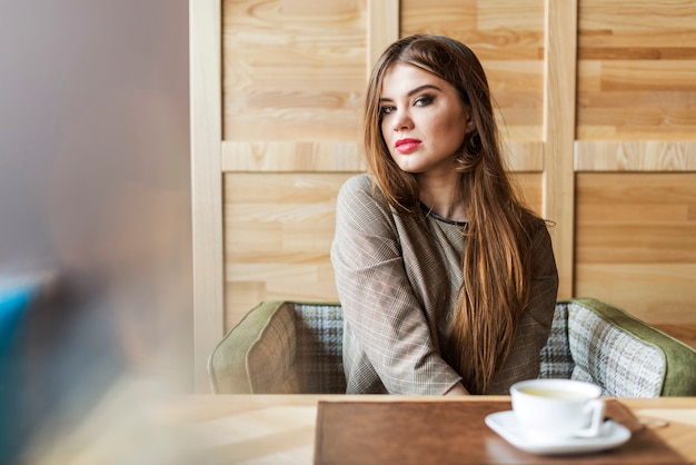 Chica pensativa en una cafetería