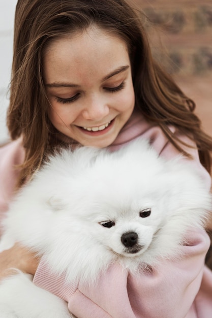 Chica y perro esponjoso vista alta