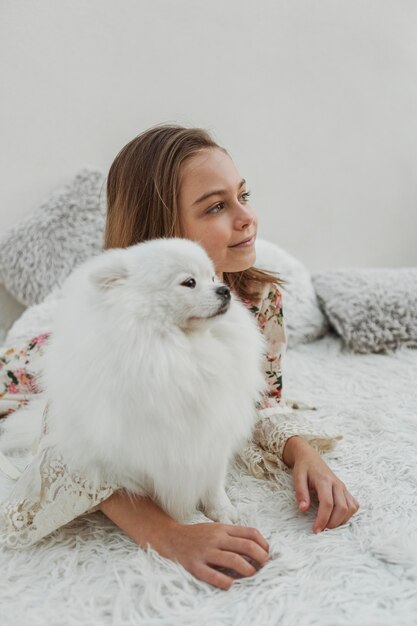 Chica y perro mullido mirando a otro lado