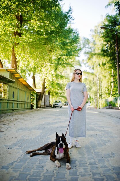 Chica con perro pit bull terrier en un paseo