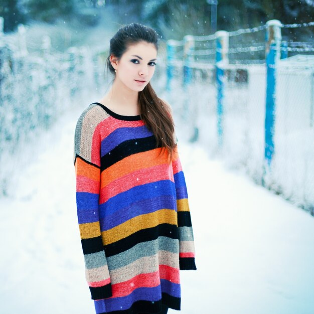 Chica de pie en el campo nevado 