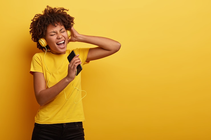 Foto gratuito la chica de piel oscura con estilo y complacida disfruta de la música de la lista de reproducción de motivación, disfruta del tiempo libre para escuchar pistas populares