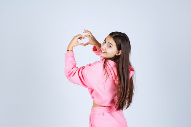 Chica en pijama rosa enviando amor