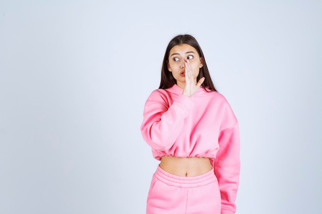 Chica en pijama rosa haciendo chismes
