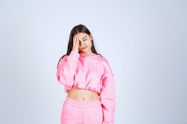 Chica en pijama rosa parece asustada y asustada