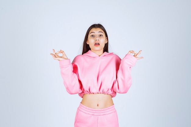 Chica en pijama rosa parece confundida y dudosa