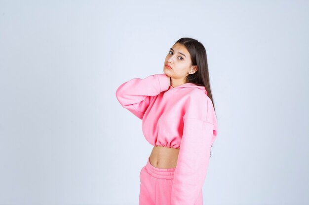 Chica en pijama rosa parece confundida y dudosa