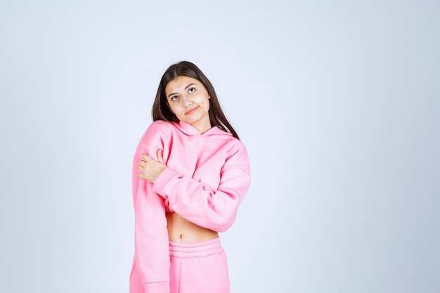 Chica en pijama rosa parece confundida y dudosa