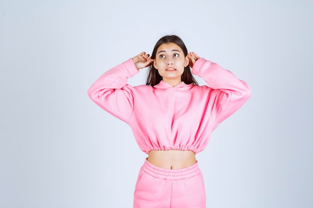 Foto gratuita chica en pijama rosa parece confundida y dudosa