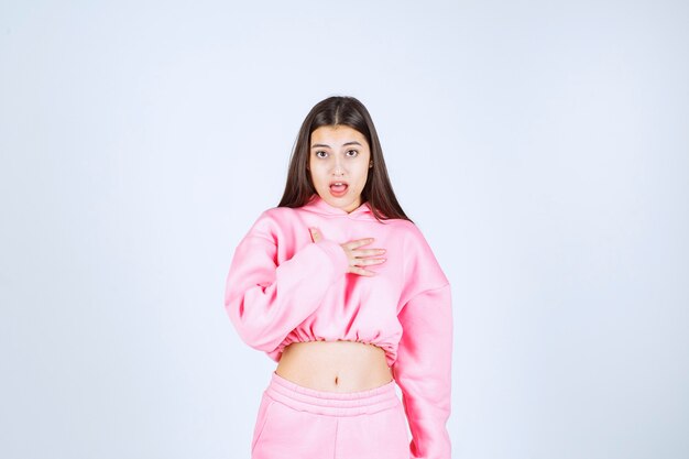 Chica en pijama rosa parece confundida e inexperta