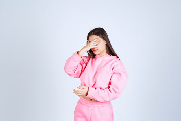 Chica en pijama rosa se ve confundida y pensativa