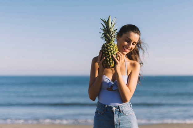 Foto gratuita chica con piña en la playa