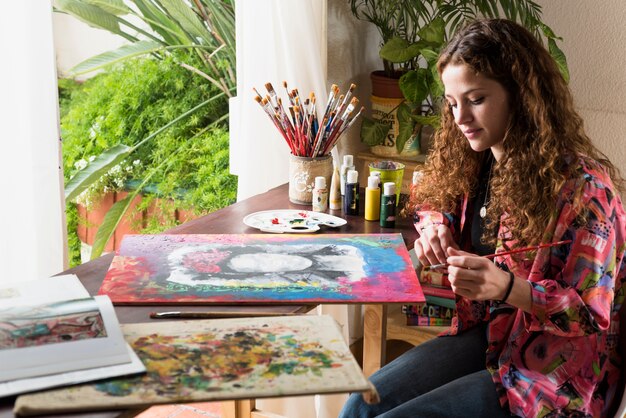 Chica pintando un cuadro en estudio de arte