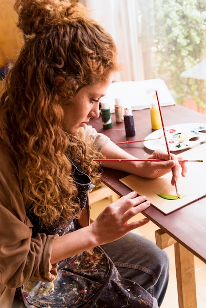 Foto gratuita chica pintando un cuadro en estudio de arte