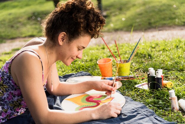 Chica pintando un cuadro en el parque