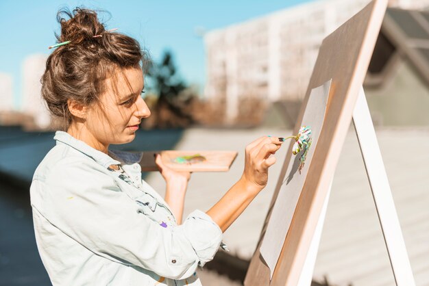 Chica pintando con flor