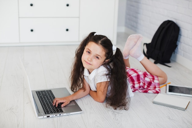 Foto gratuita chica en el piso con la computadora portátil