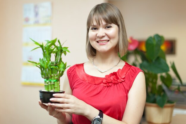 Chica con la planta de bambú afortunado