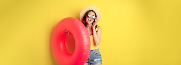 Foto gratuita chica de playa elegante con anillo de natación riendo y sonriendo en vacaciones de verano viaje por mar feliz de pie