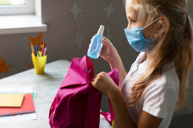 Foto gratuita chica poniendo su desinfectante en su mochila