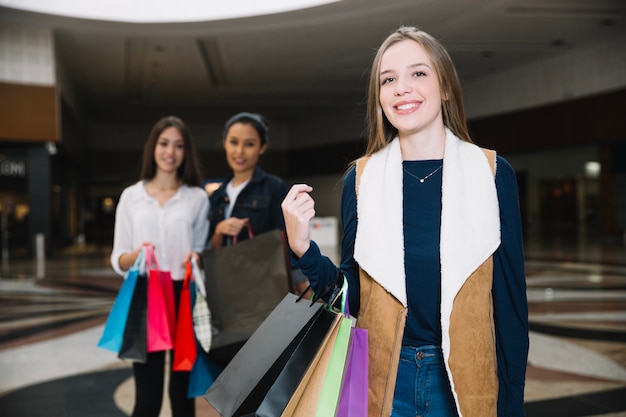 Chica posando con bolsas en el centro comercial