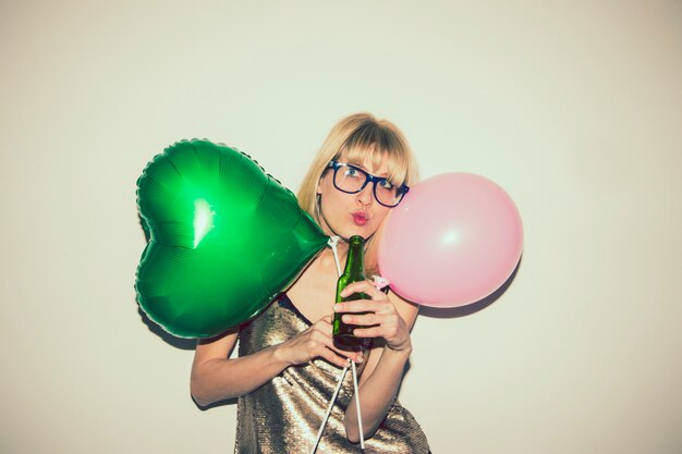 Chica posando con globos y cerveza