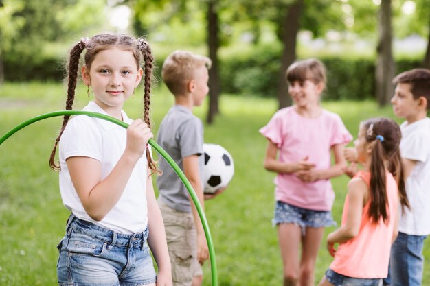 Chica posando con hula hoop junto a amigos