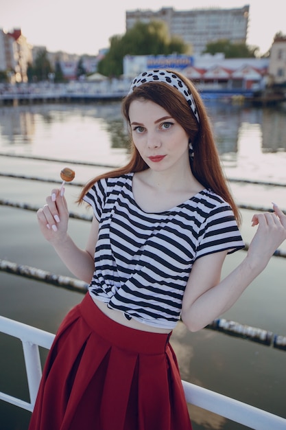 Foto gratuita chica posando con el mar de fondo en un puerto marítimo