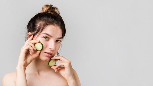 Chica posando con rodajas de pepino