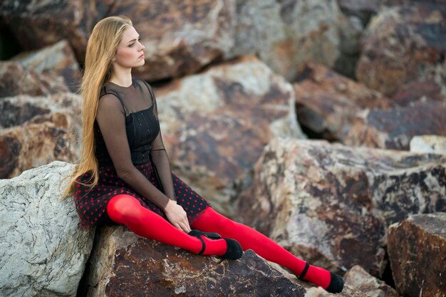 Chica posando sobre las rocas