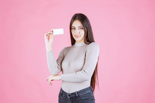 Chica presentando su tarjeta de visita a un socio comercial