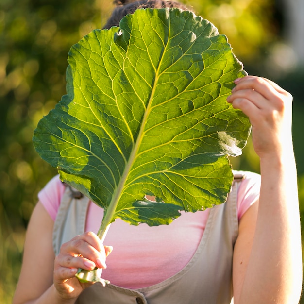 Chica de primer plano con hoja de lechuga