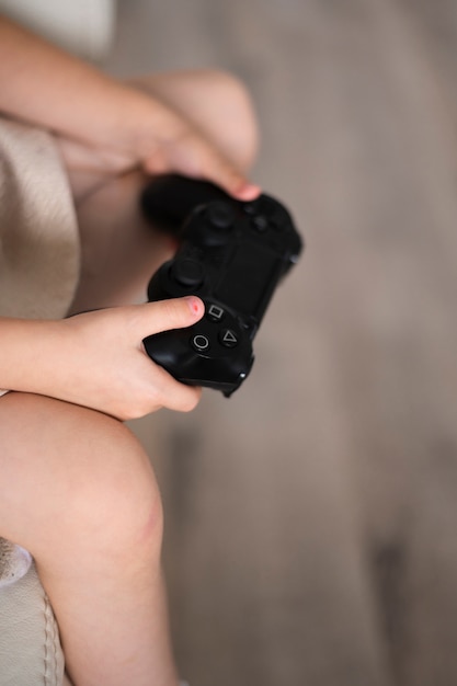 Chica de primer plano con joystick en casa