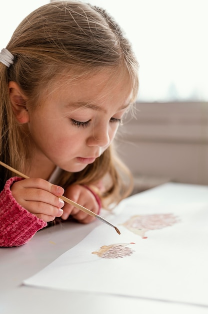 Foto gratuita chica de primer plano pintando en el interior