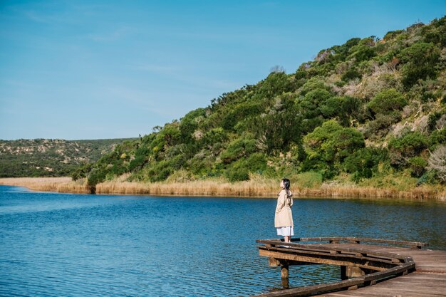 chica en puente y vista al lago