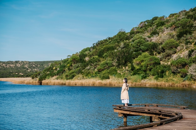 chica en puente y vista al lago