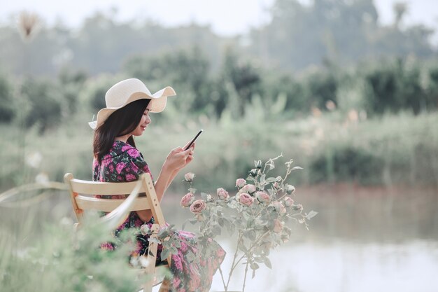 Chica que llevaba un vestido de flores sentado en la naturaleza