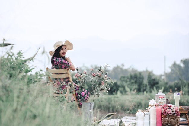 Chica que llevaba un vestido de flores sentado en la naturaleza
