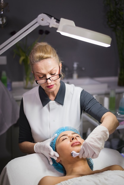 Chica recibiendo tratamiento facial en salón de belleza