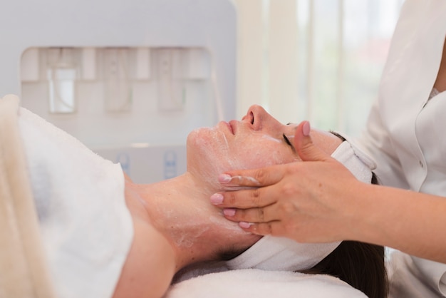 Chica recibiendo tratamiento facial en salón de belleza