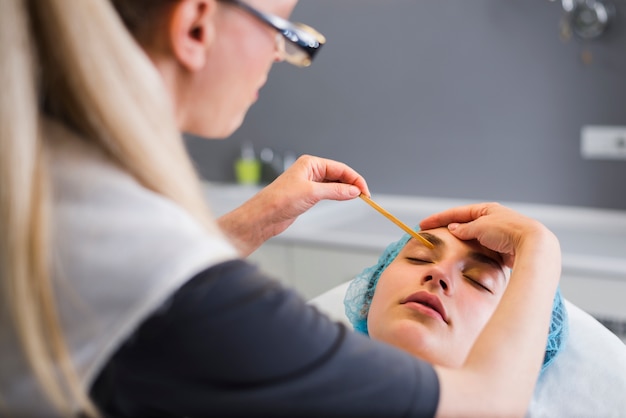 Foto gratuita chica recibiendo tratamiento facial en salón de belleza