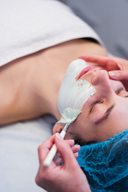 Chica recibiendo tratamiento facial en salón de belleza